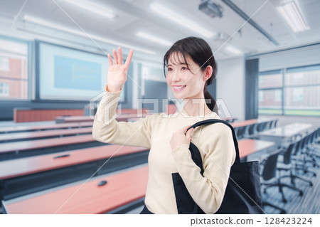 一名年輕的女大學生走進大學教室 一名年輕的女大學生走進大學教室 128423224