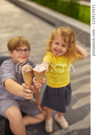 Rainbow treats. Kids showing ice cream cones while smiling playfully 128423431