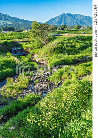 A rural landscape with a blue sky and Mount Aso (Minamiaso Village) in the background A rural landscape with a blue sky and Mount Aso (Minamiaso Village) in the background 128423564