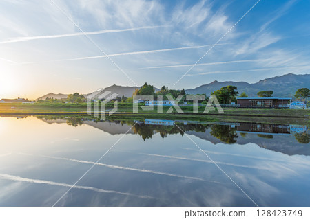 A spectacular reflection of the sunset and Mount Aso in the background (Aso, Minamiaso Village) 128423749