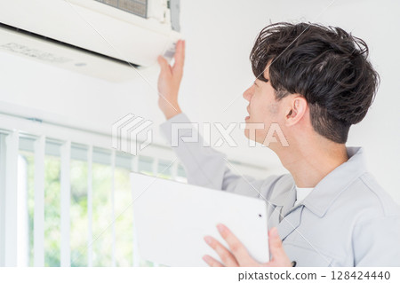 一名男工人檢查空調的運作。 128424440