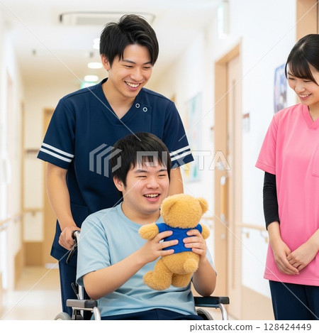 推著輪椅。男女照顧者面帶微笑地與一位殘障人士互動。使用者的笑容。 推著輪椅。男女照顧者面帶微笑地與一位殘障人士互動。使用者的笑容。 128424449