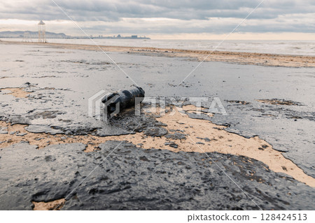 Oil spill pollutes beach with plastic waste, highlighting environmental disaster and sea pollution crisis in Anapa. Oil spill pollutes beach with plastic waste, highlighting environmental disaster and sea pollution crisis in Anapa. 128424513