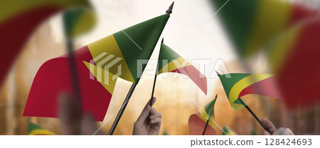 Congo flags in their hands on a blurred urban background 128424693