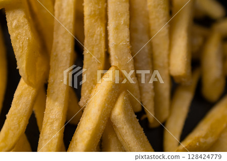 Perfectly golden french fries, generously seasoned with coarse salt, offering a classic fast food experience, ideal for casual dining and satisfying cravings Perfectly golden french fries, generously seasoned with coarse salt, offering a classic fast food experience, ideal for casual dining and satisfying cravings 128424779