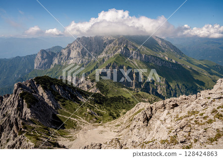 Rugged Alpine Peaks And Verdant Valleys In The Grigna Massif: Scenic Mountain Landscape In Lombardy Region Of Northern Italy Near Lake Como Rugged Alpine Peaks And Verdant Valleys In The Grigna Massif: Scenic Mountain Landscape In Lombardy Region Of Northern Italy Near Lake Como 128424863