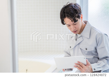 一名男工作人員正在檢查浴室。 128424872