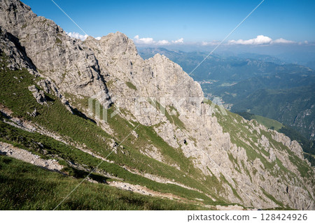 Rugged Alpine Peaks And Verdant Valleys In The Grigna Massif: Scenic Mountain Landscape In Lombardy Region Of Northern Italy Near Lake Como Rugged Alpine Peaks And Verdant Valleys In The Grigna Massif: Scenic Mountain Landscape In Lombardy Region Of Northern Italy Near Lake Como 128424926