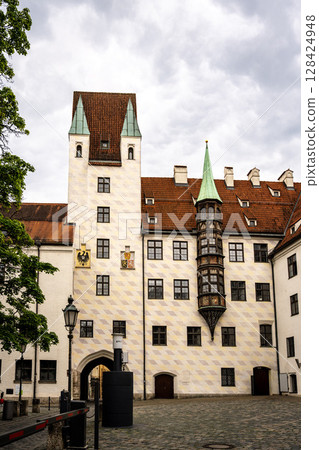 Alter Hof - Historic Old Court In Munich With Medieval Architecture And Tower: Beautiful Facade With Red Tiled Roofs, Green Turrets, And Decorative Windows In The Heart Of The Bavarian Capital Near Alter Hof - Historic Old Court In Munich With Medieval Architecture And Tower: Beautiful Facade With Red Tiled Roofs, Green Turrets, And Decorative Windows In The Heart Of The Bavarian Capital Near 128424948