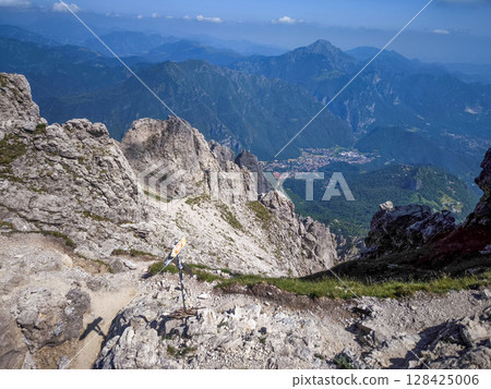 Rugged Alpine Peaks And Verdant Valleys In The Grigna Massif: Scenic Mountain Landscape In Lombardy Region Of Northern Italy Near Lake Como Rugged Alpine Peaks And Verdant Valleys In The Grigna Massif: Scenic Mountain Landscape In Lombardy Region Of Northern Italy Near Lake Como 128425006