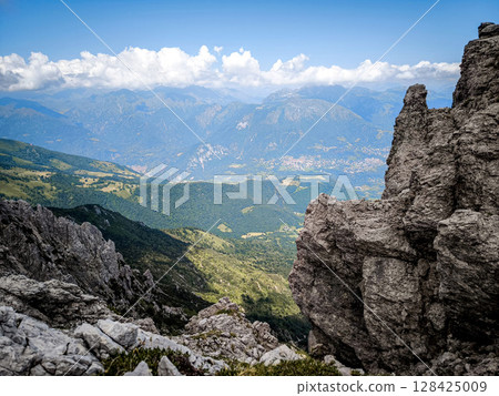 Rugged Alpine Peaks And Verdant Valleys In The Grigna Massif: Scenic Mountain Landscape In Lombardy Region Of Northern Italy Near Lake Como Rugged Alpine Peaks And Verdant Valleys In The Grigna Massif: Scenic Mountain Landscape In Lombardy Region Of Northern Italy Near Lake Como 128425009
