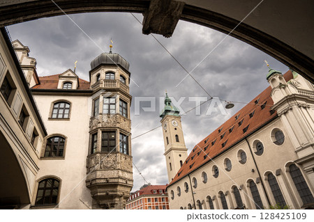 Historic Church Of The Holy Spirit In Munich: Elegant Baroque Architecture With Tower And Facade Near Marienplatz Under Dramatic Cloudy Sky Historic Church Of The Holy Spirit In Munich: Elegant Baroque Architecture With Tower And Facade Near Marienplatz Under Dramatic Cloudy Sky 128425109