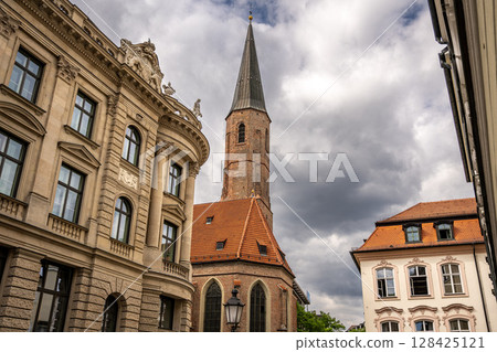 Historic St. Jakobs Church in Munich Near Sendlinger Tor: Elegant Gothic Architecture with Tall Steeple and Red Roof Surrounded by Classic Bavarian Buildings under Dramatic Cloudy Sky Historic St. Jakobs Church in Munich Near Sendlinger Tor: Elegant Gothic Architecture with Tall Steeple and Red Roof Surrounded by Classic Bavarian Buildings under Dramatic Cloudy Sky 128425121