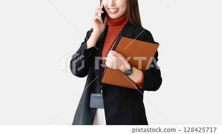 微笑的女人/女商人在智慧型手機上交談 128425717