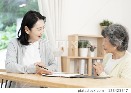 Care manager/care manager conducting a home visit Care manager/care manager conducting a home visit 128425847