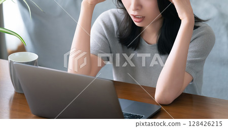 一位女士在使用電腦時遇到困難 一位女士在使用電腦時遇到困難 128426215