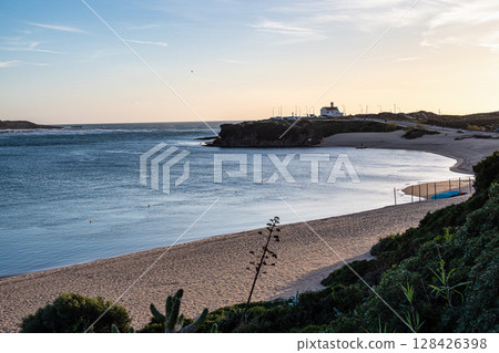 Praia do Farol in Vila Nova de Milfontes, Portugal is located at the mouth of the Mira River on the northern bank. Praia do Farol in Vila Nova de Milfontes, Portugal is located at the mouth of the Mira River on the northern bank. 128426398