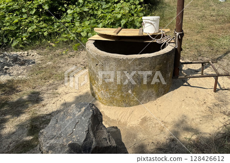 A mine well with concrete rings. Topped with white sand for protection and filtration. 128426612
