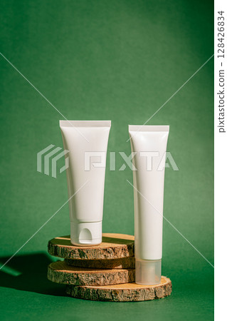Two skincare tubes against a green backdrop 128426834