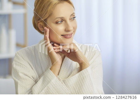 Portrait of young woman with natural make up sitting in spa salon and smiling. Skin care concept. Portrait of young woman with natural make up sitting in spa salon and smiling. Skin care concept. 128427616