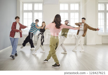 Group of young girls and guys dancing in dance studio Group of young girls and guys dancing in dance studio 128427621