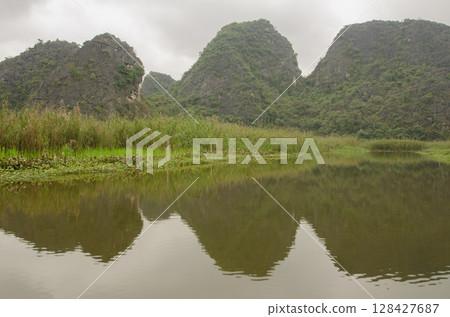 Limestone cliffs reflected in the water. 128427687