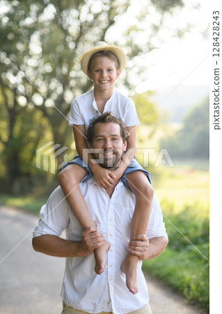 Happy father carrying son on his shoulders. 128428243
