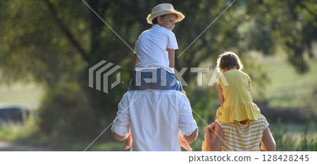 Banner with copy space. Parents carrying two kids on shoulders. Banner with copy space. Parents carrying two kids on shoulders. 128428245