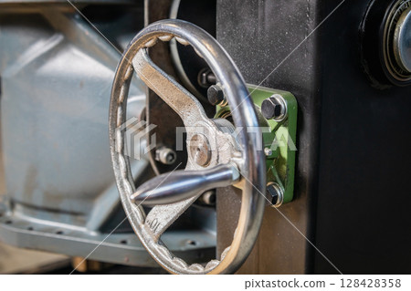 Industrial wheel controlling heavy machinery in a factory setting 128428358