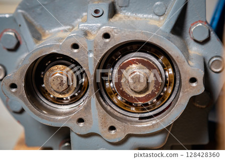 Two bearings showing wear and tear inside industrial gearbox Two bearings showing wear and tear inside industrial gearbox 128428360
