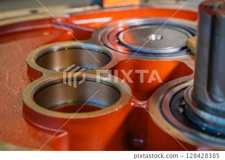 Industrial gearbox showing three bronze bushings and ball bearings Industrial gearbox showing three bronze bushings and ball bearings 128428385