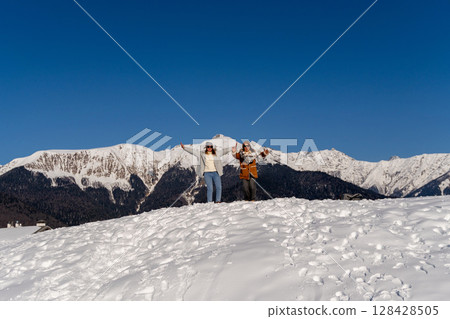 Mountains Winter Couple Joyful Celebration: Snowy Peak, Happy Tourists, Winter Vacation. 128428505