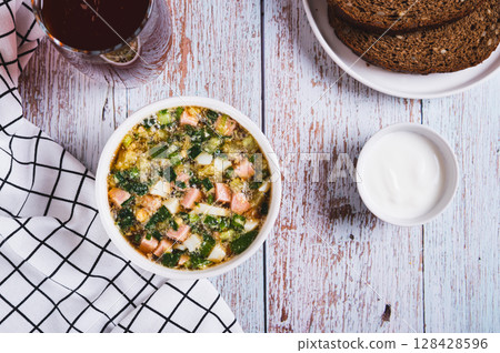 Traditional cold vegetable soup with kvass in a bowl on the table top view Traditional cold vegetable soup with kvass in a bowl on the table top view 128428596