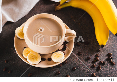 Blended frozen banana coffee in a cup on the table Blended frozen banana coffee in a cup on the table 128428611