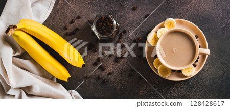 Blended frozen banana coffee in a cup on the table top view web banner Blended frozen banana coffee in a cup on the table top view web banner 128428617