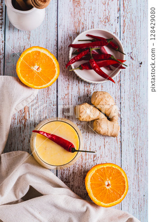 Orange ginger smoothie with pepper for weight loss in a glass top and vertical view Orange ginger smoothie with pepper for weight loss in a glass top and vertical view 128429080