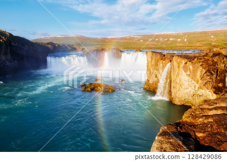Nice views of the bright sunlit powerful Godafoss cascade. Location Skjalfandafljot river, Iceland, Europe. Beauty world. Nice views of the bright sunlit powerful Godafoss cascade. Location Skjalfandafljot river, Iceland, Europe. Beauty world. 128429086