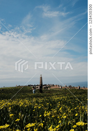 Scenic landscape of Cabo da Roca lighthouse with blue sky dramatic cliffs Atlantic Ocean rugged coastline in Sintra Portugal popular travel destination viewpoint with natural vegetation. High quality 128430300