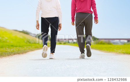 Back view of two middle-aged women walking in sportswear 128432986