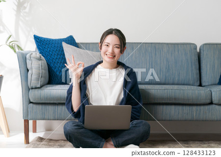 Young woman relaxing in the living room Young woman relaxing in the living room 128433123