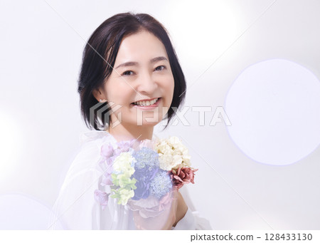 Beauty Middle-aged woman holding a bouquet Beauty Middle-aged woman holding a bouquet 128433130
