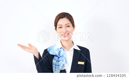Smiling female store clerk/reception staff guiding customers 128434105