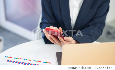 使用筆記型電腦和智慧型手機的女性商務人士 使用筆記型電腦和智慧型手機的女性商務人士 128434132