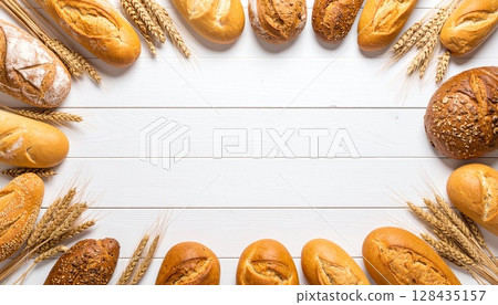 Bread and wheat ears on a white wooden table | Natural bakery background from above 128435157