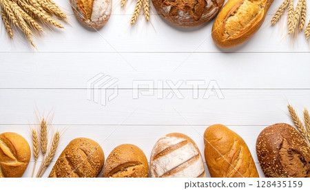 Bread and wheat ears on a white wooden table | Natural bakery background from above 128435159