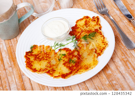 Potato pancakes served with sour cream 128435342