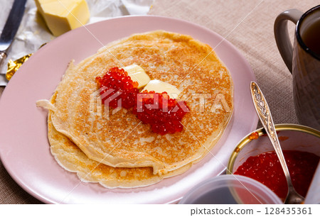 Pancakes served with red caviar and butter Pancakes served with red caviar and butter 128435361