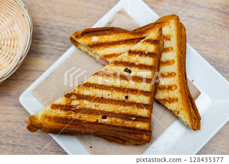 Crispy toasted Spanish bikini sandwich with ham and cheese Crispy toasted Spanish bikini sandwich with ham and cheese 128435377
