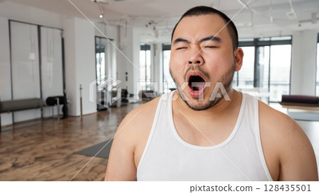 A sleepy Japanese male instructor yawning loudly 128435501