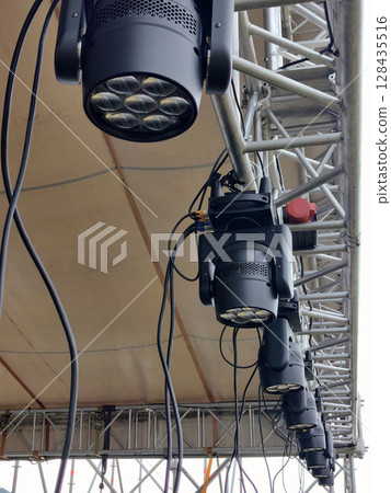 stage lighting setup prepares for an outdoor concert in bright daylight. closeup. stage lighting setup prepares for an outdoor concert in bright daylight. closeup. 128435516